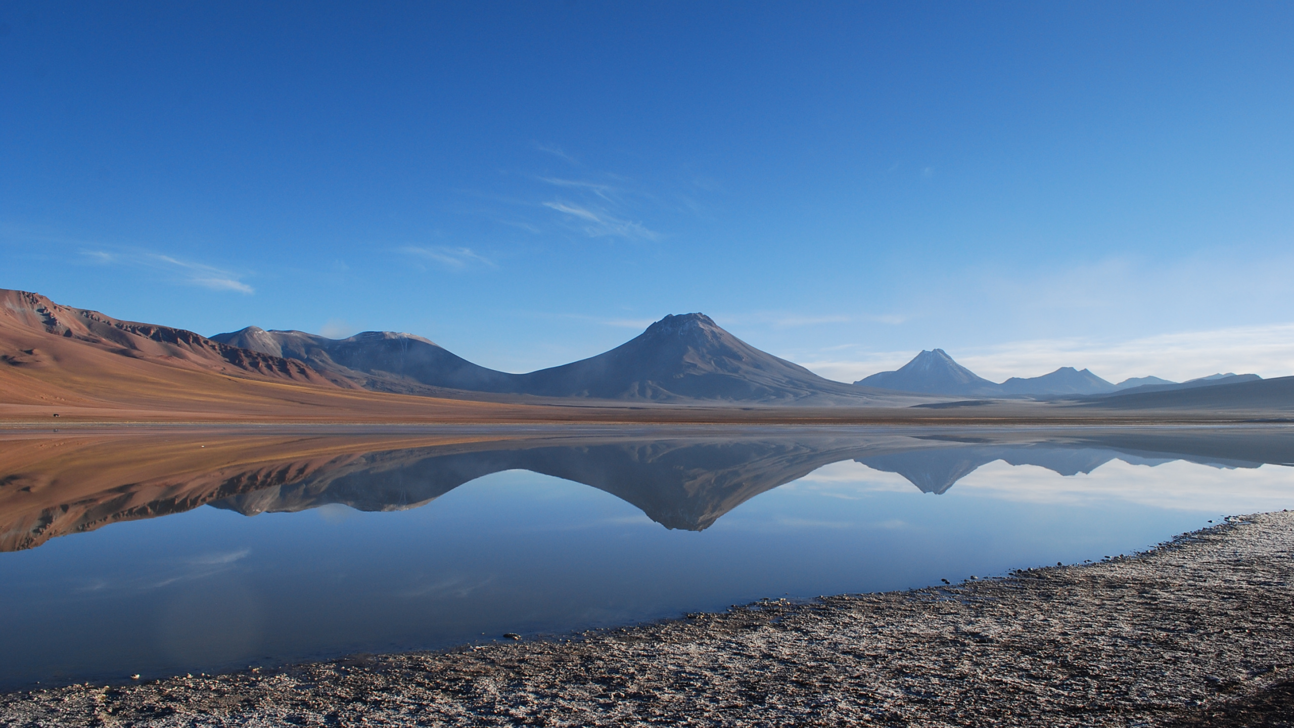 Brown Mountain Near Lake Under Blue Sky During Daytime. Wallpaper in 2560x1440 Resolution