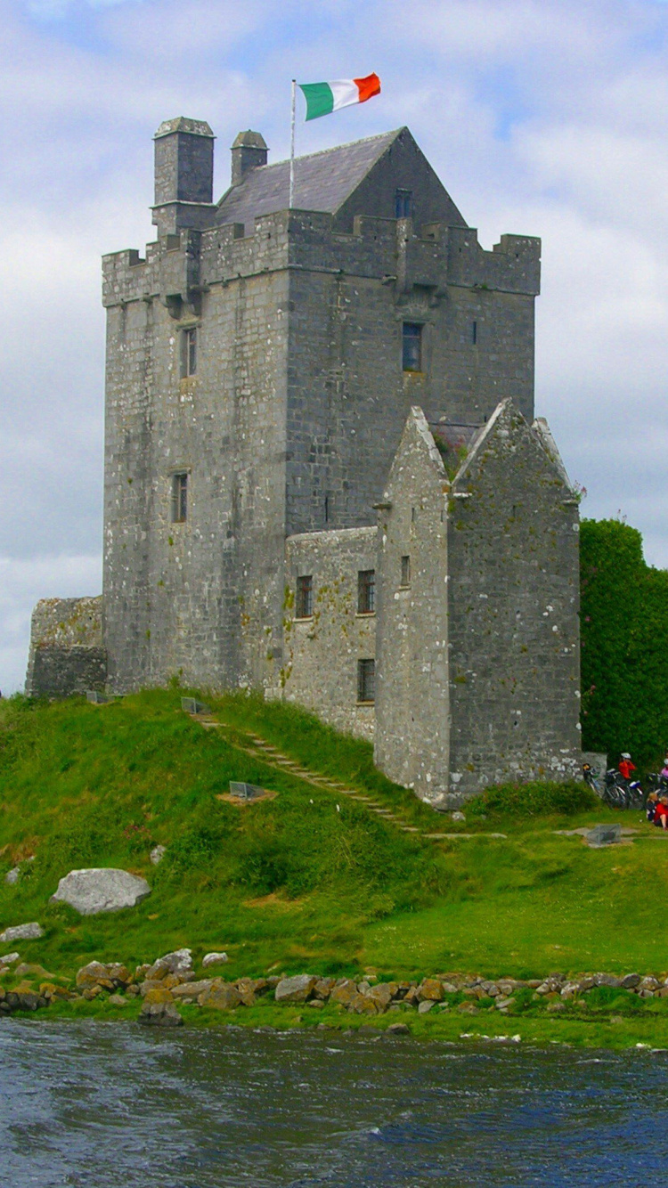 Graues Betongebäude in Der Nähe Einer Grünen Wiese Unter Weißen Wolken Tagsüber Clouds. Wallpaper in 750x1334 Resolution
