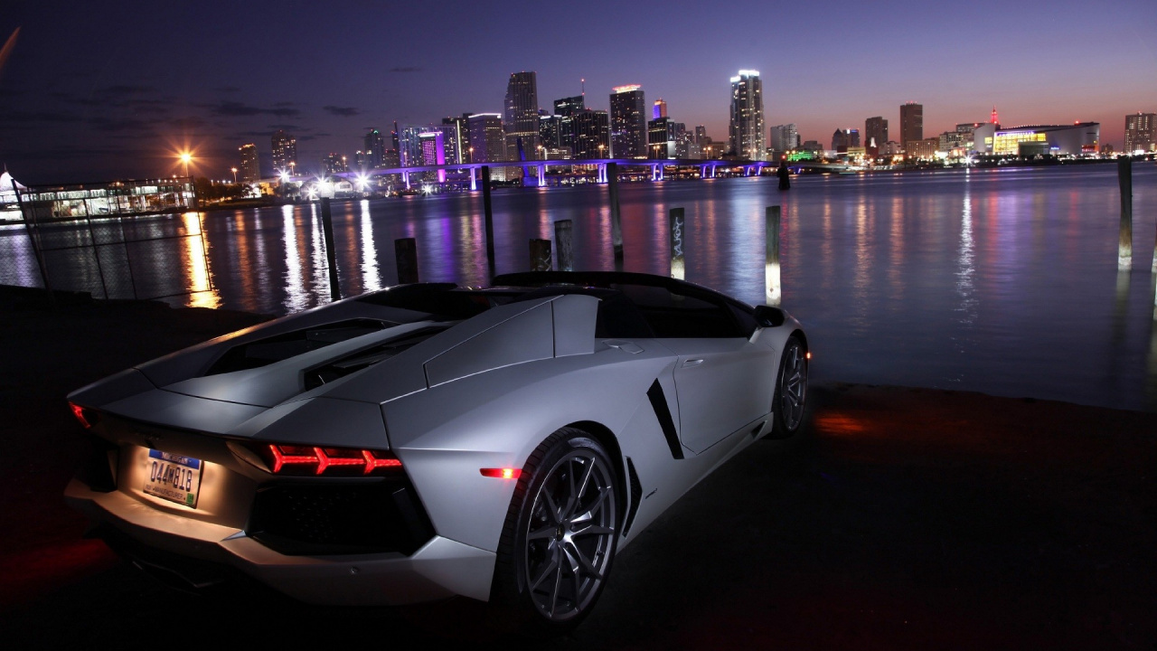 White Lamborghini Aventador Parked Near Body of Water During Night Time. Wallpaper in 1280x720 Resolution