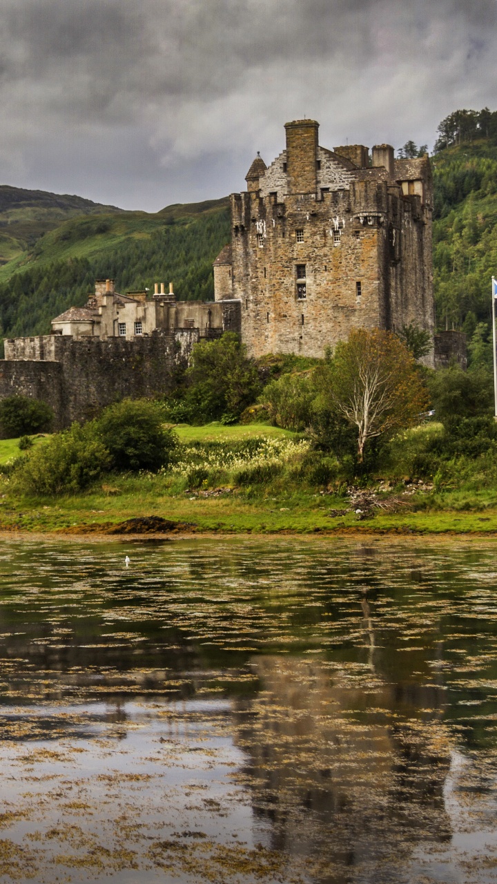 Edificio de Hormigón Gris Cerca Del Cuerpo de Agua Bajo un Cielo Nublado Durante el Día. Wallpaper in 720x1280 Resolution