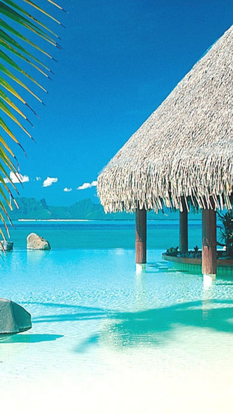 Parasols en Bois Marron Sur la Plage de Sable Blanc Pendant la Journée. Wallpaper in 750x1334 Resolution