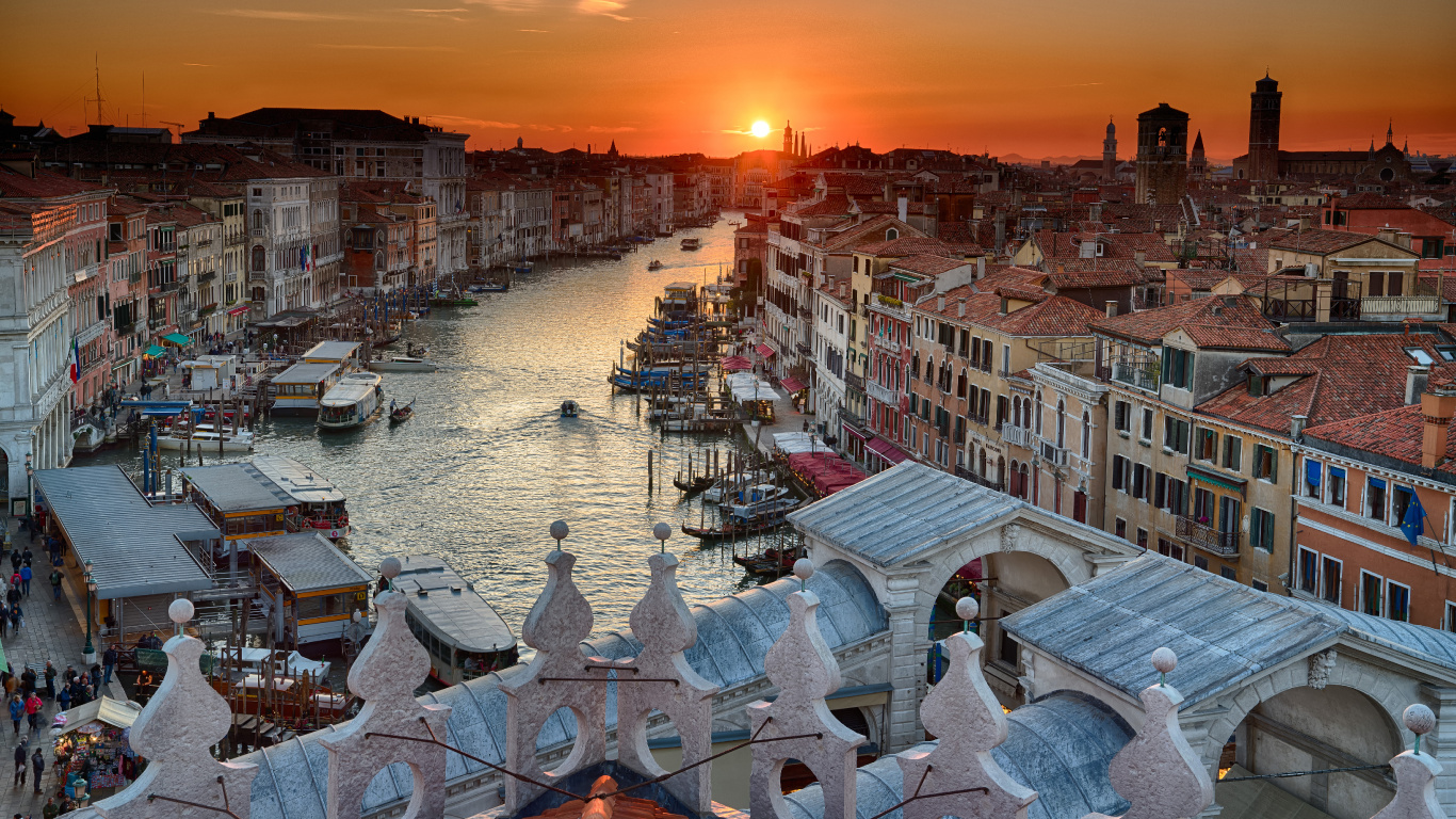 White and Brown Concrete Houses Near Body of Water During Sunset. Wallpaper in 1366x768 Resolution