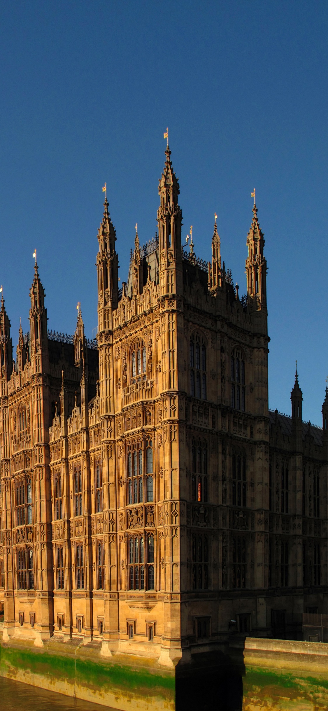 Edificio de Hormigón Marrón Cerca Del Cuerpo de Agua Durante el Día. Wallpaper in 1125x2436 Resolution