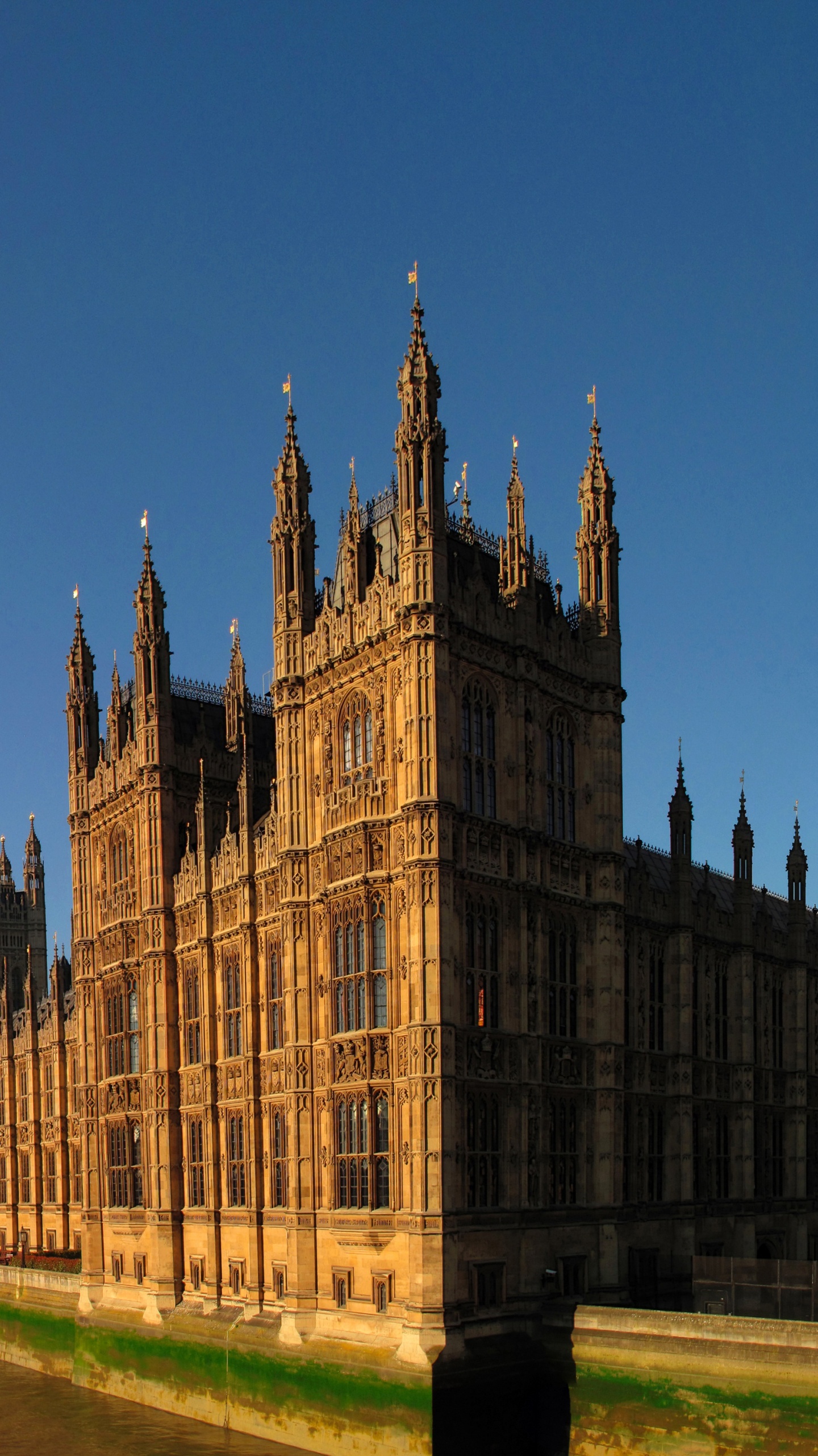 Bâtiment en Béton Brun Près D'un Plan D'eau Pendant la Journée. Wallpaper in 1440x2560 Resolution
