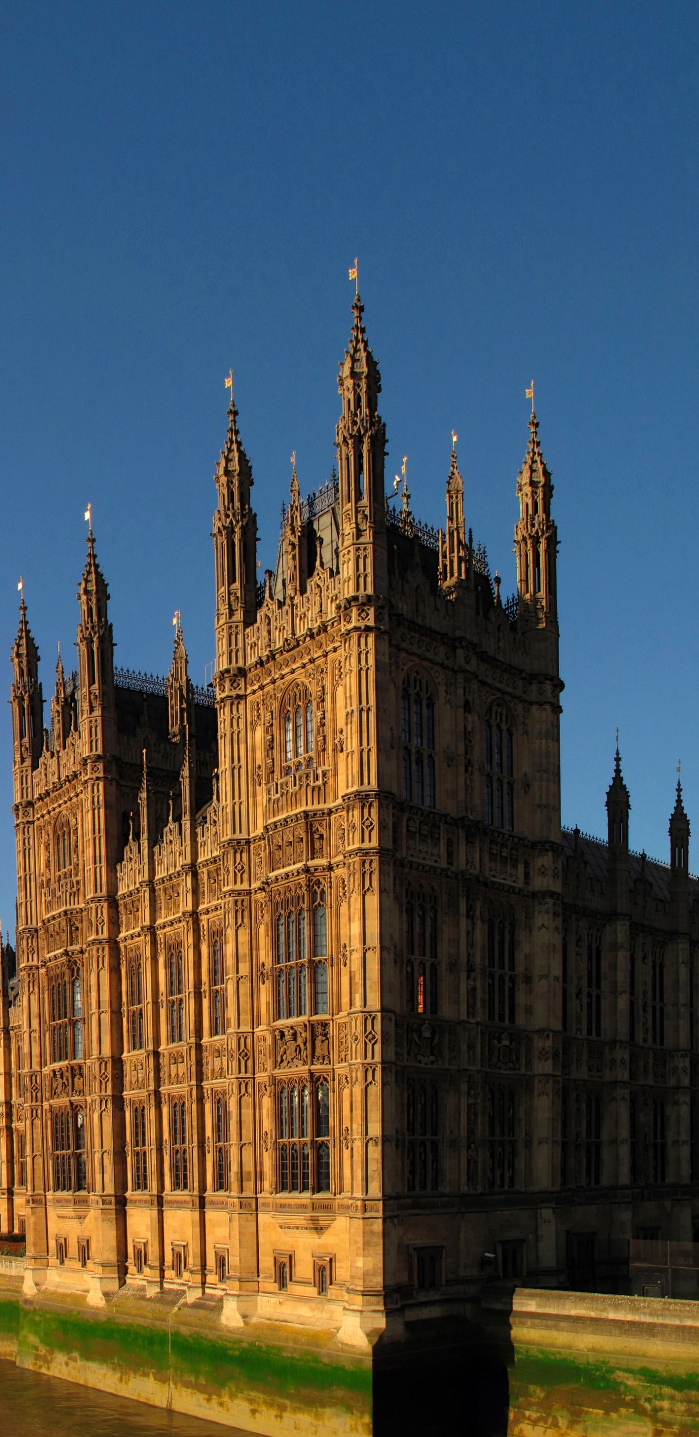 Brown Concrete Building Near Body of Water During Daytime. Wallpaper in 1440x2960 Resolution