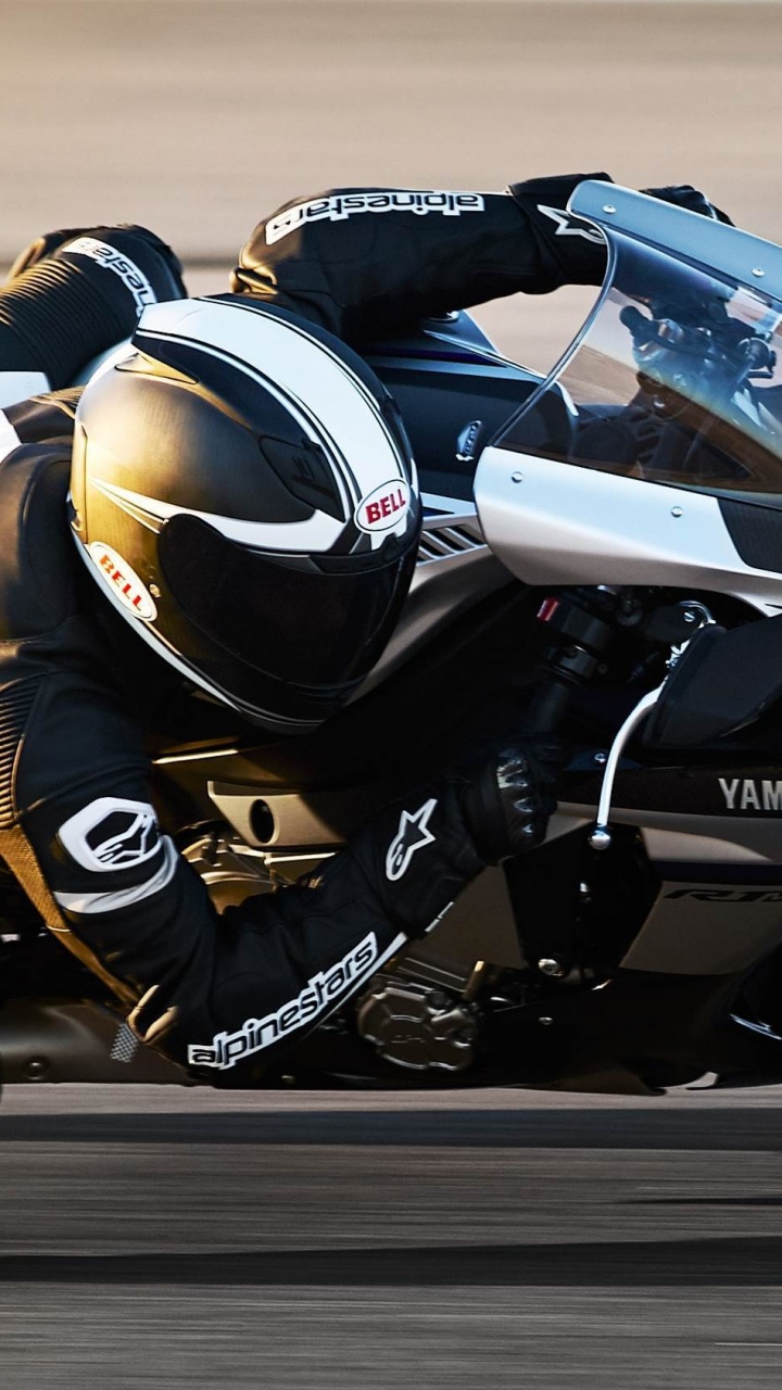 Mann im Schwarz-weißen Motorradanzug, Der Auf Einem Weißen Und Schwarzen Sportmotorrad Fährt. Wallpaper in 720x1280 Resolution