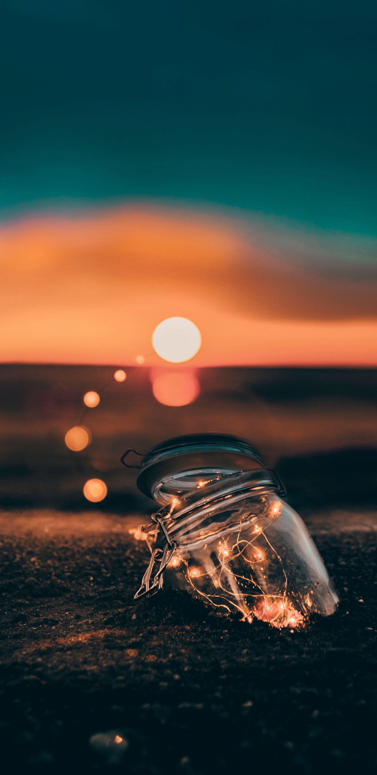 Bouteille en Verre Clair Sur le Sable Brun Pendant le Coucher du Soleil. Wallpaper in 1440x2960 Resolution