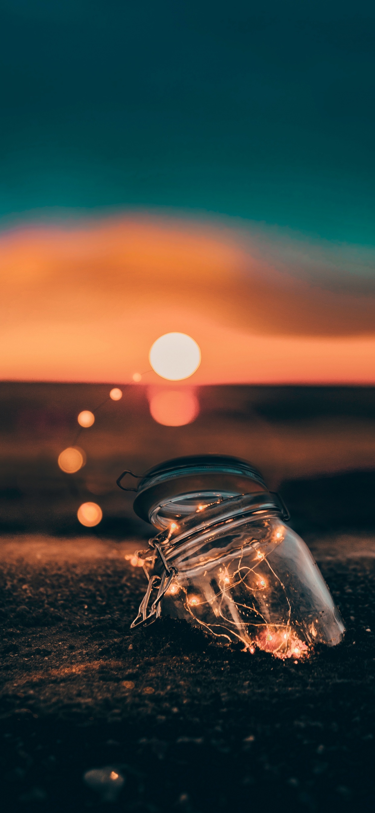 Clear Glass Bottle on Brown Sand During Sunset. Wallpaper in 1242x2688 Resolution