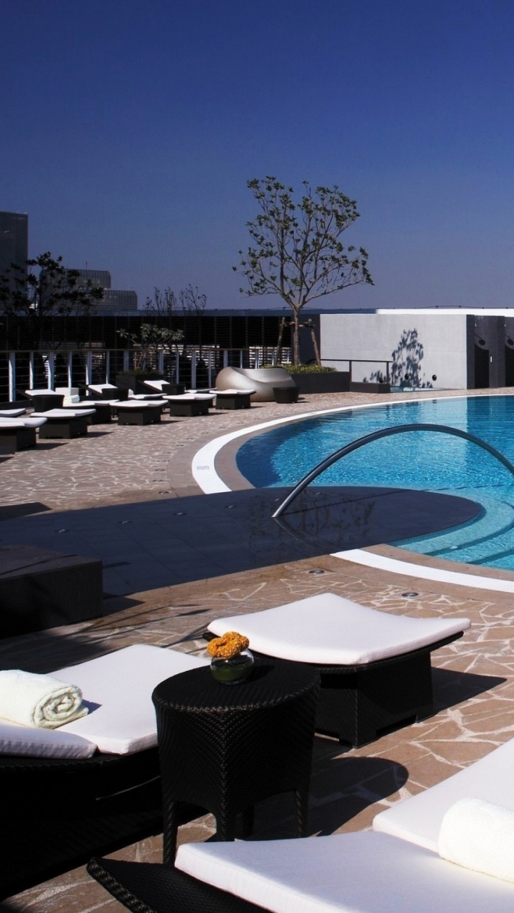 White Outdoor Lounge Chairs Beside Swimming Pool During Daytime. Wallpaper in 720x1280 Resolution
