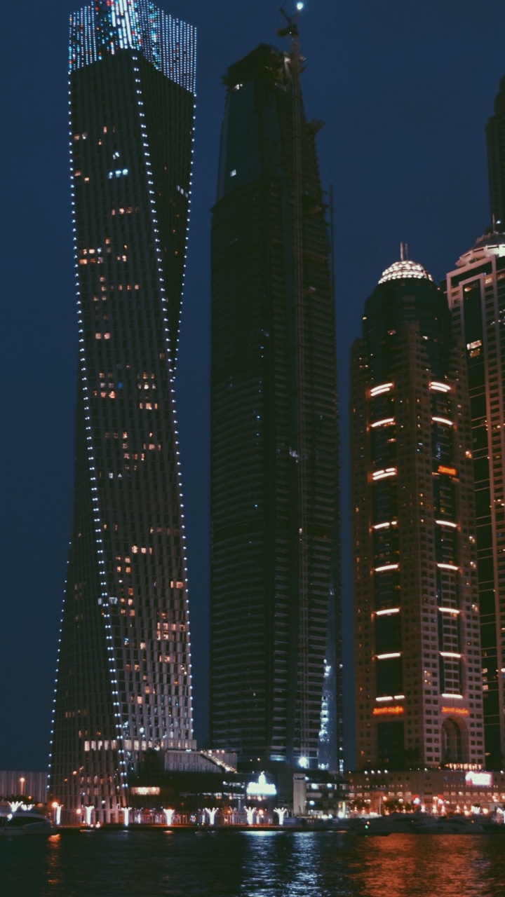 City Skyline Across Body of Water During Night Time. Wallpaper in 720x1280 Resolution