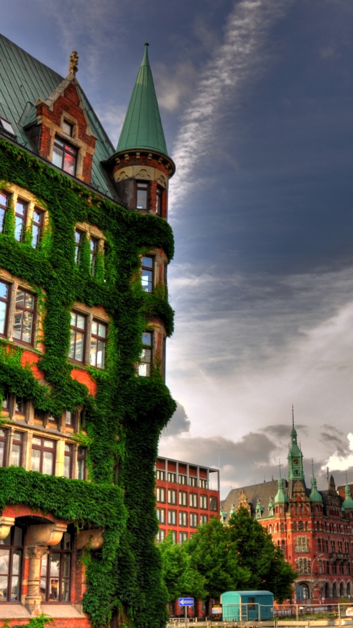 Bâtiment en Béton Vert et Marron Sous Les Nuages Gris. Wallpaper in 720x1280 Resolution