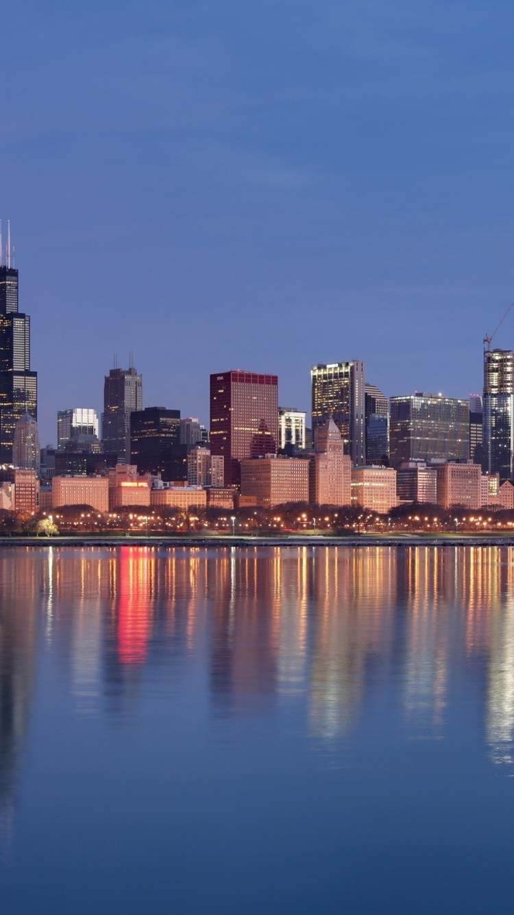 Horizonte de la Ciudad a Través Del Cuerpo de Agua Durante la Noche.. Wallpaper in 750x1334 Resolution