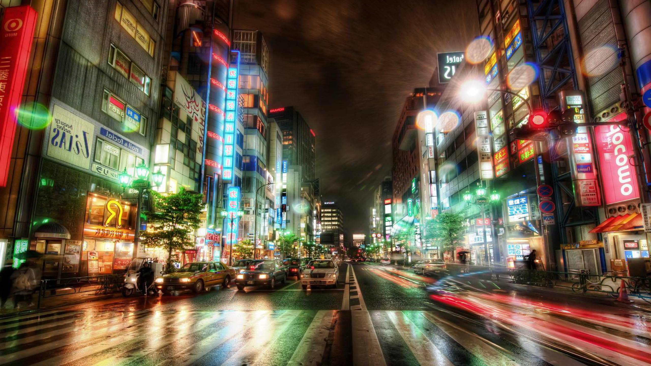 Voitures Sur Route Entre Les Immeubles de Grande Hauteur Pendant la Nuit. Wallpaper in 2560x1440 Resolution