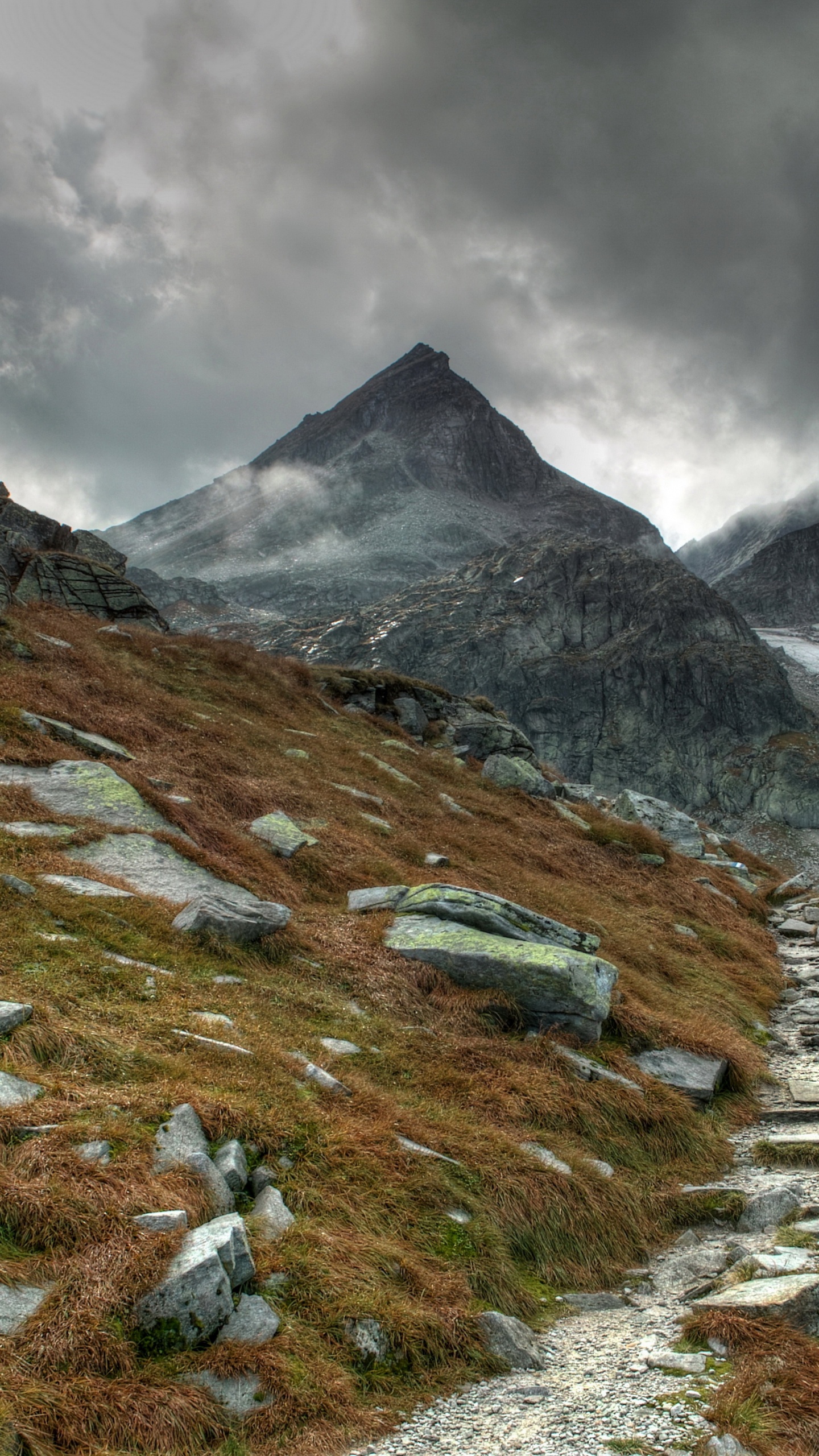 Green Grass Field Near Mountain Under Cloudy Sky During Daytime. Wallpaper in 1440x2560 Resolution