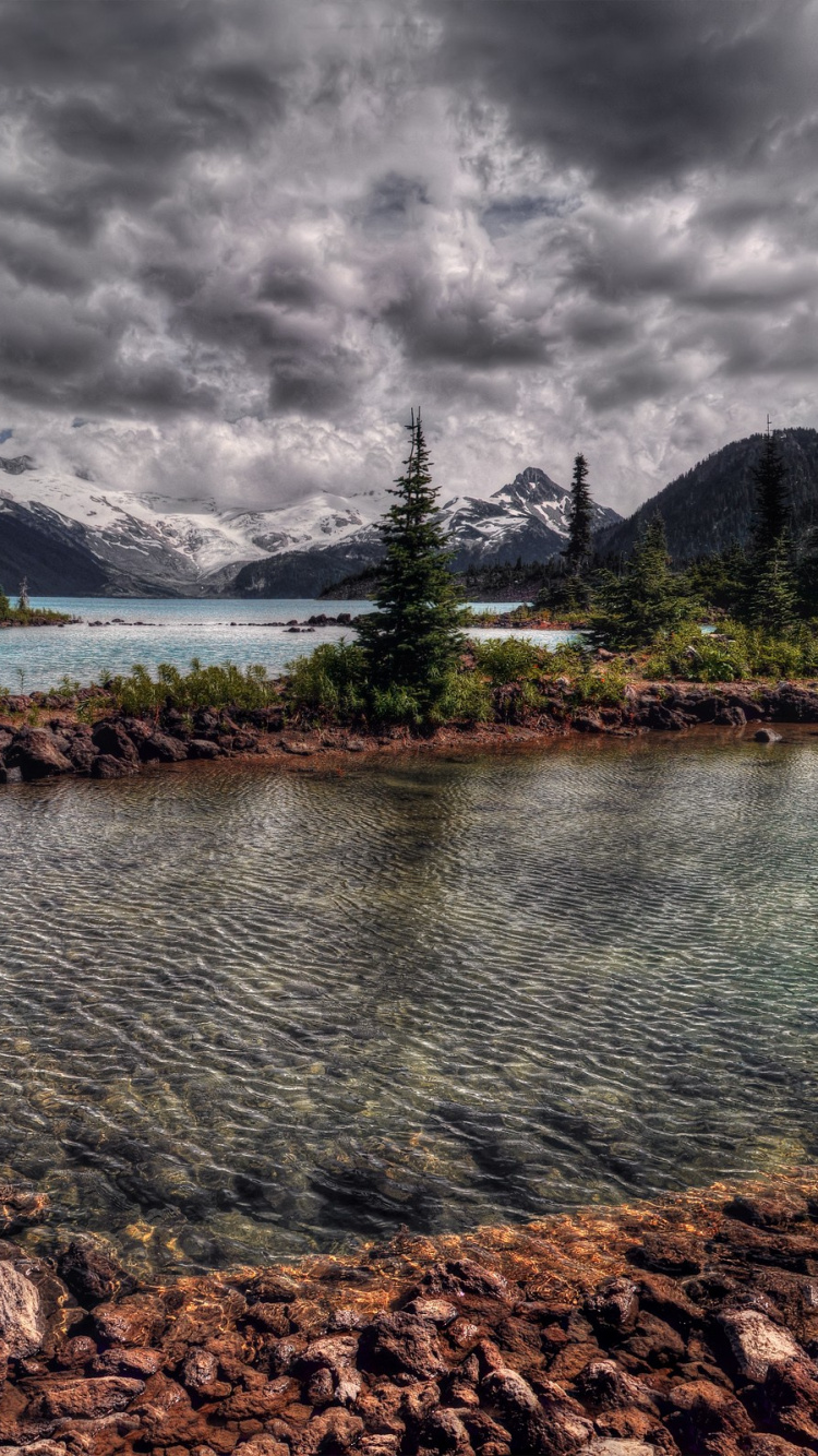 Green Trees Near Lake Under Cloudy Sky During Daytime. Wallpaper in 750x1334 Resolution
