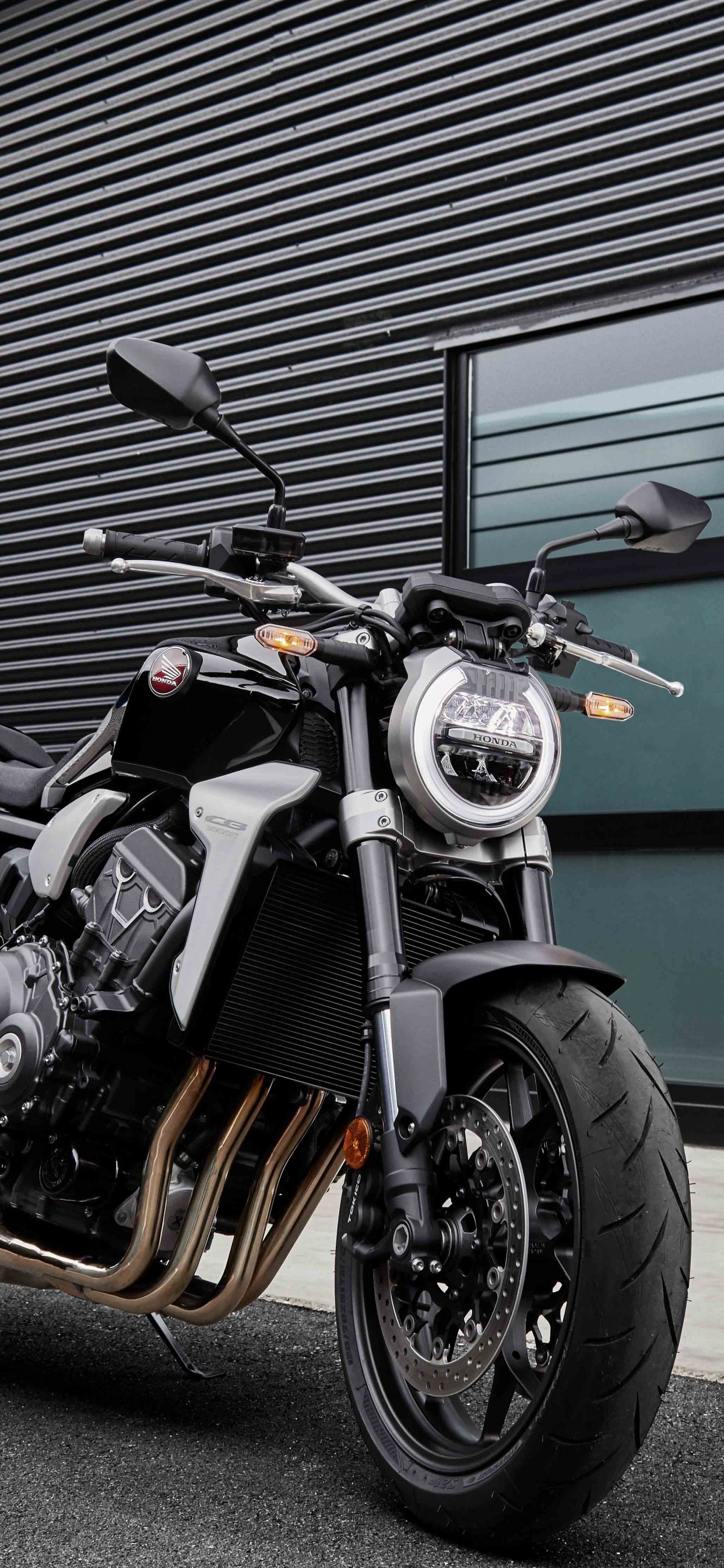 Man in Black Jacket Standing Beside Black and Silver Cruiser Motorcycle. Wallpaper in 1242x2688 Resolution