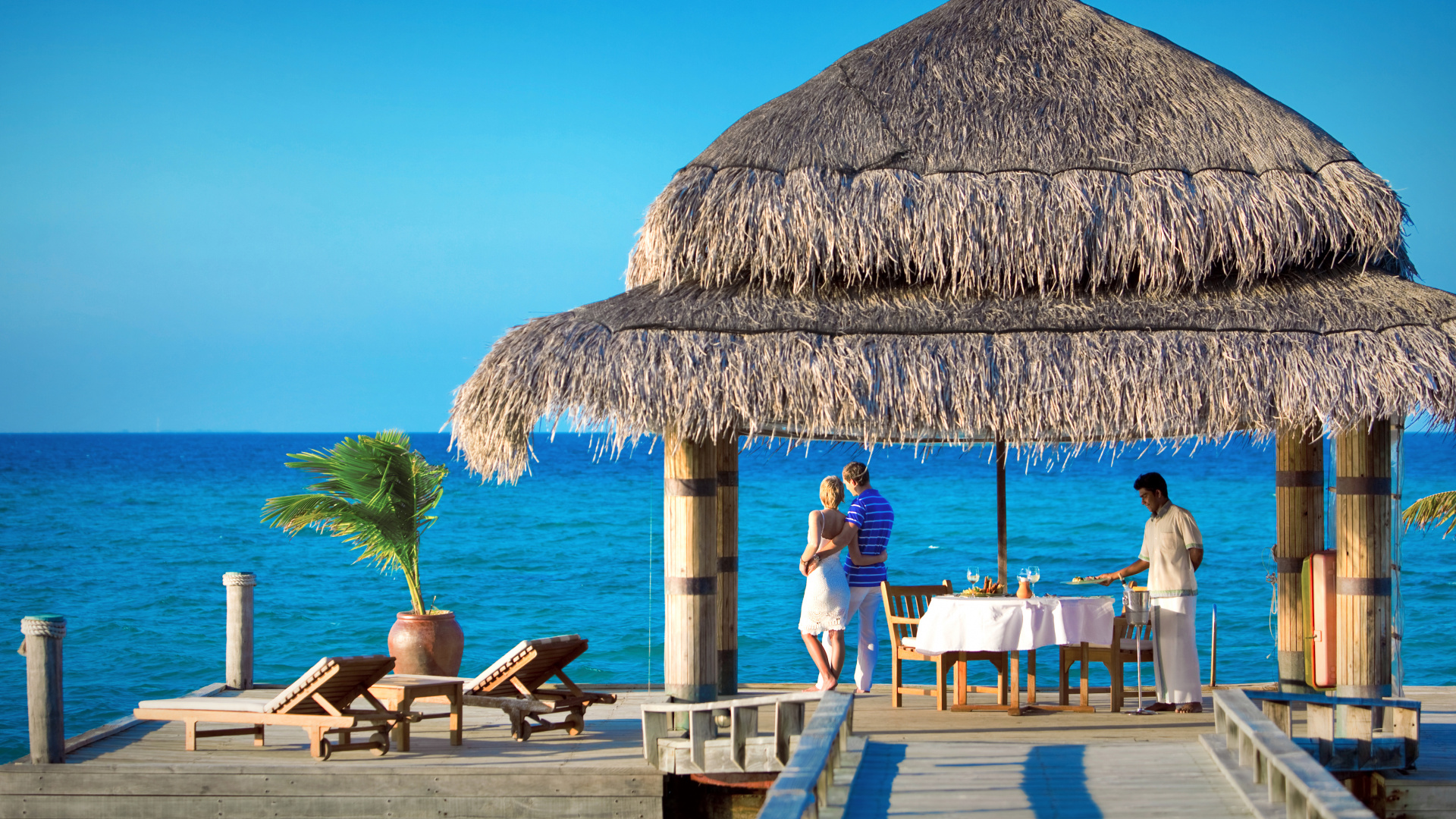 People Sitting on Brown Wooden Chairs Near Brown Nipa Hut During Daytime. Wallpaper in 1920x1080 Resolution