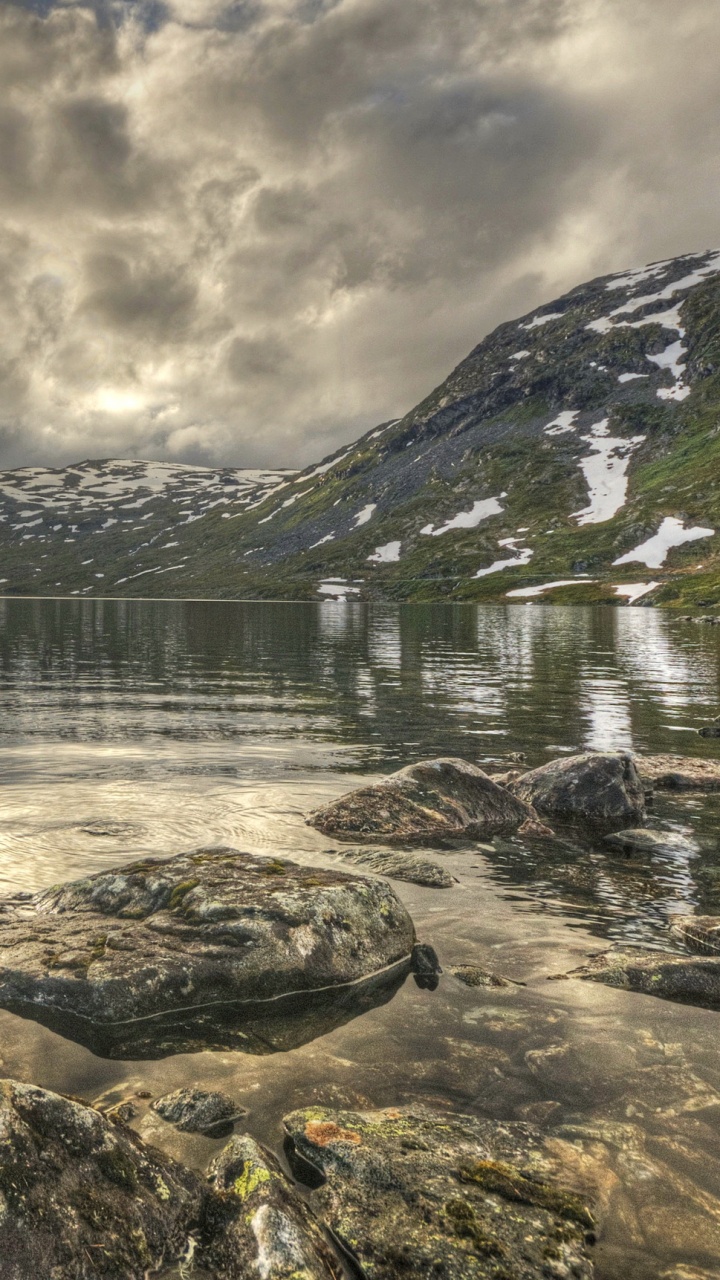 Brown Wooden House on Rocky Shore Near Mountain Under Cloudy Sky During Daytime. Wallpaper in 720x1280 Resolution