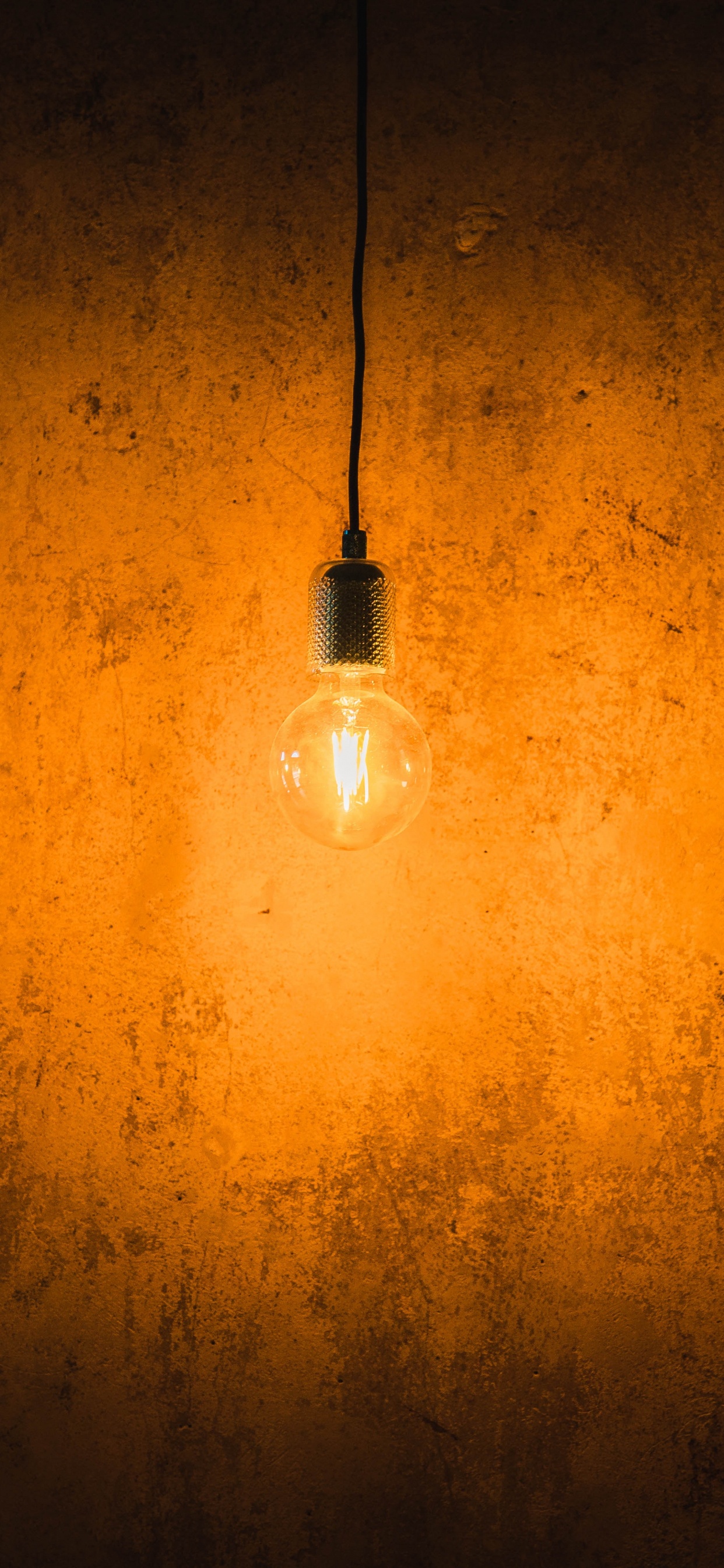 Bombilla de Luz Blanca Encendida en la Pared Naranja. Wallpaper in 1242x2688 Resolution
