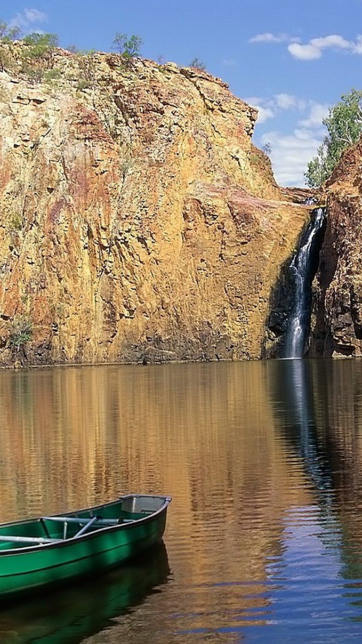 Green Boat on Lake Near Brown Rocky Mountain During Daytime. Wallpaper in 720x1280 Resolution