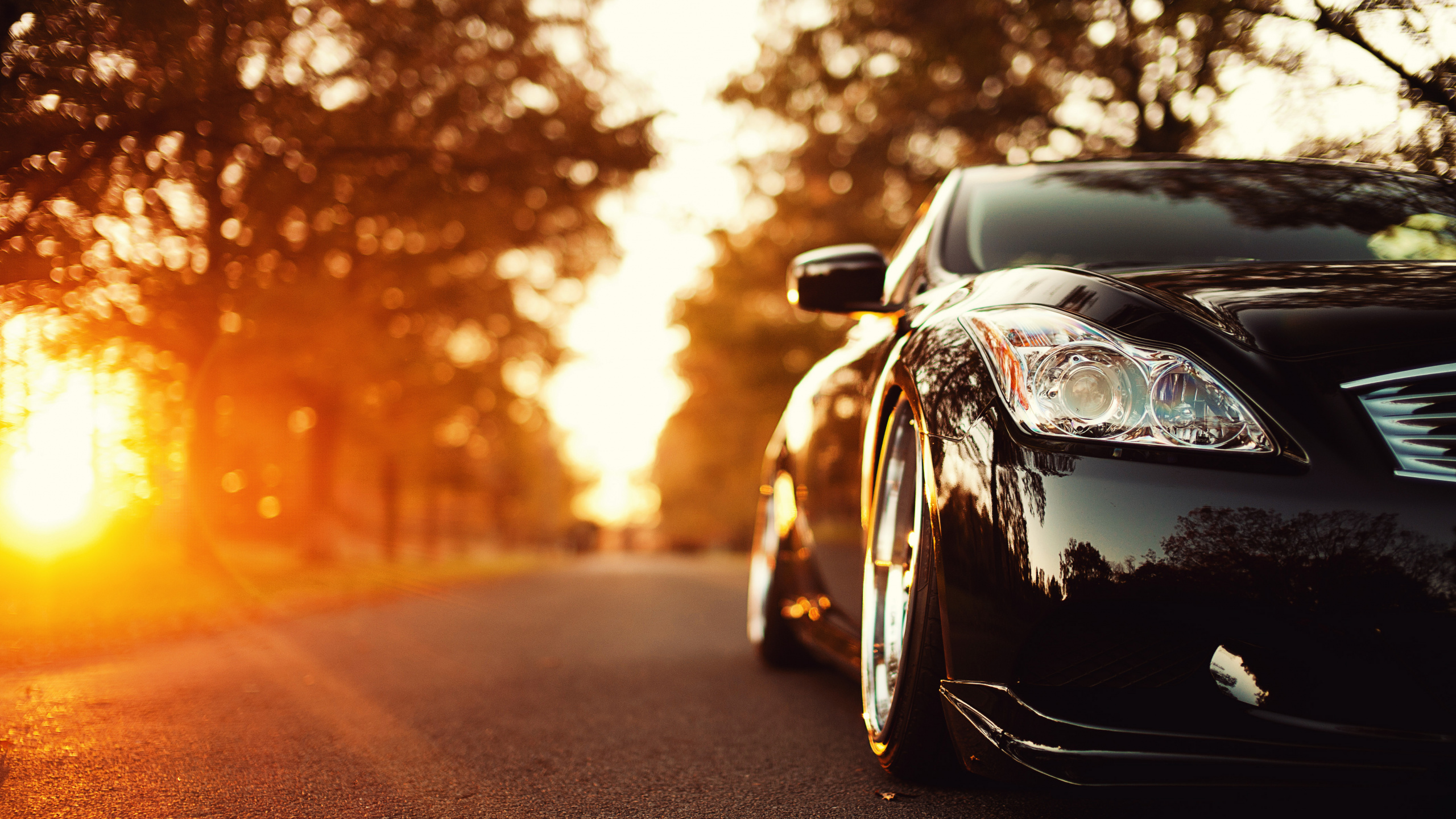 Schwarzer Porsche 911 Unterwegs Bei Sonnenuntergang. Wallpaper in 2560x1440 Resolution