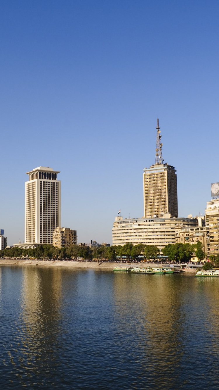 Horizonte de la Ciudad a Través Del Cuerpo de Agua Durante el Día.. Wallpaper in 750x1334 Resolution