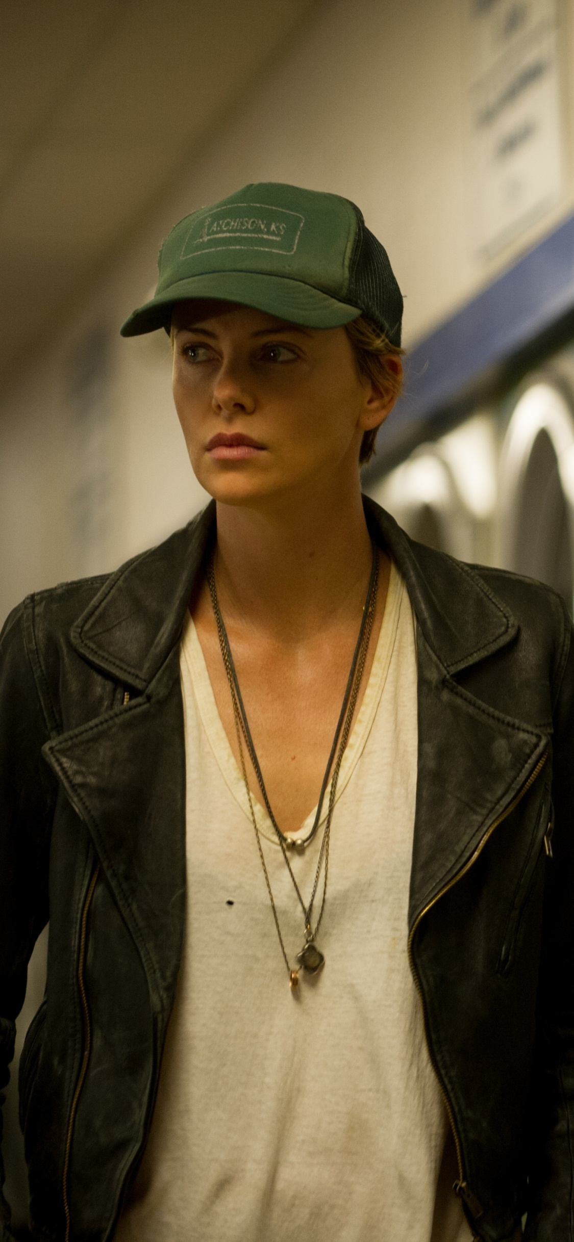 Woman in Black Leather Jacket Standing Near Front Load Washing Machine. Wallpaper in 1125x2436 Resolution