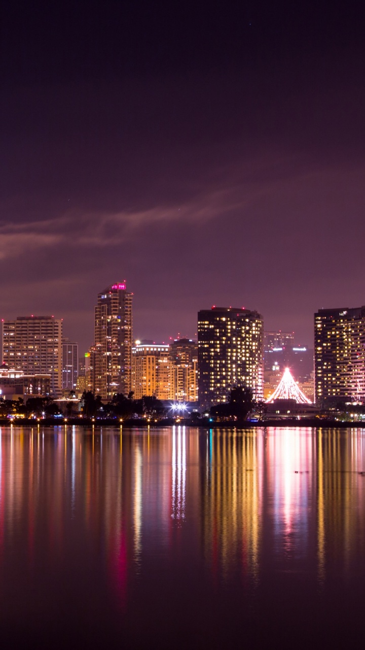 City Skyline Across Body of Water During Night Time. Wallpaper in 720x1280 Resolution