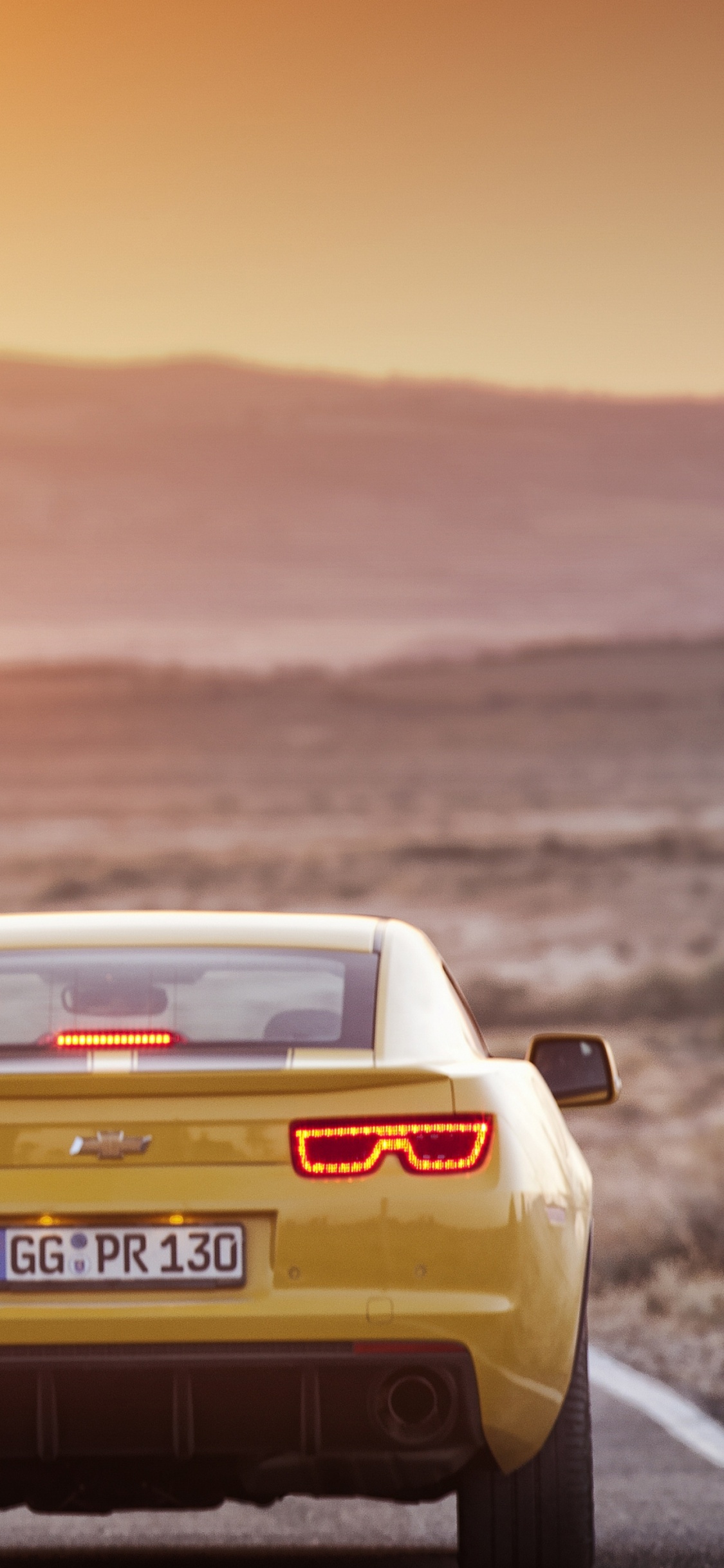 Mann in Schwarzem T-Shirt Und Schwarzer Hose Steht Neben Weißem Porsche 911. Wallpaper in 1125x2436 Resolution