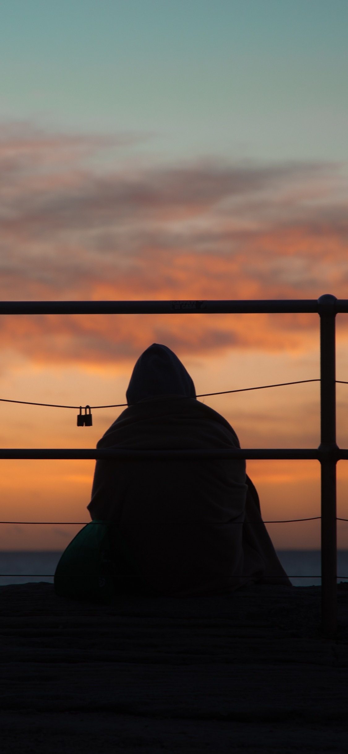 Silhouette of Person Sitting on Wooden Dock During Sunset. Wallpaper in 1125x2436 Resolution