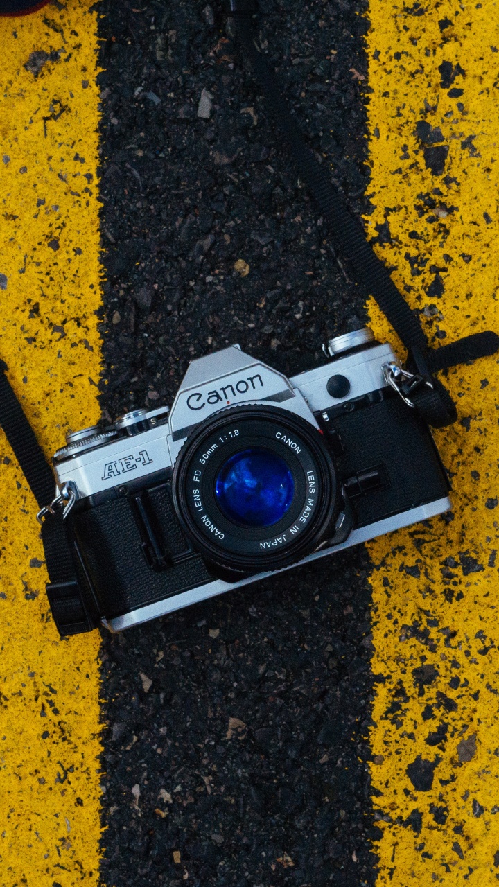 Cámara Réflex Digital Nikon Negra y Plateada Sobre Superficie Marrón y Negra. Wallpaper in 720x1280 Resolution