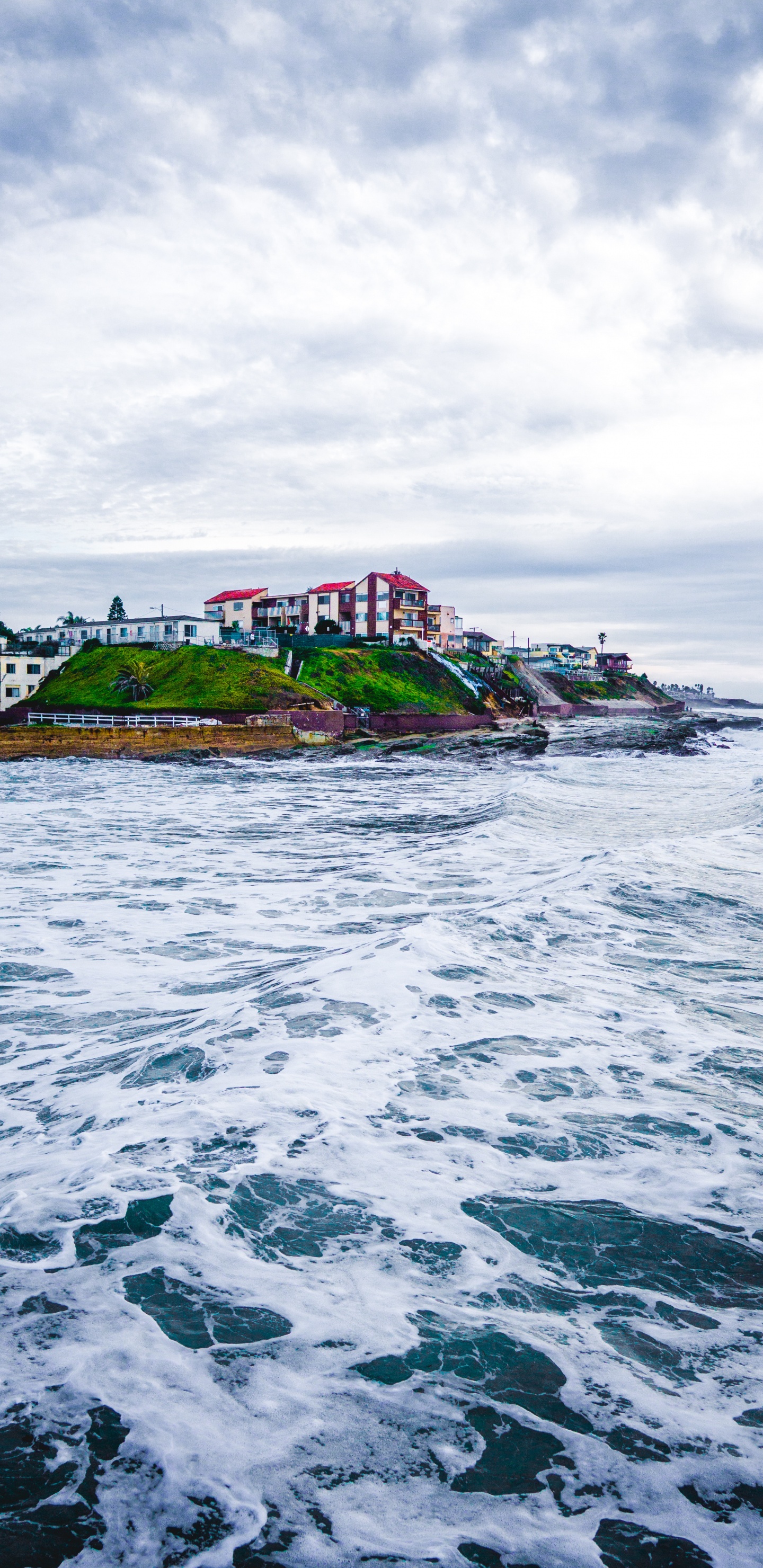 White Concrete Building Near Body of Water During Daytime. Wallpaper in 1440x2960 Resolution