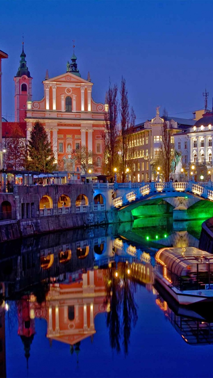 Edificio de Hormigón Marrón Cerca Del Cuerpo de Agua Durante la Noche. Wallpaper in 720x1280 Resolution