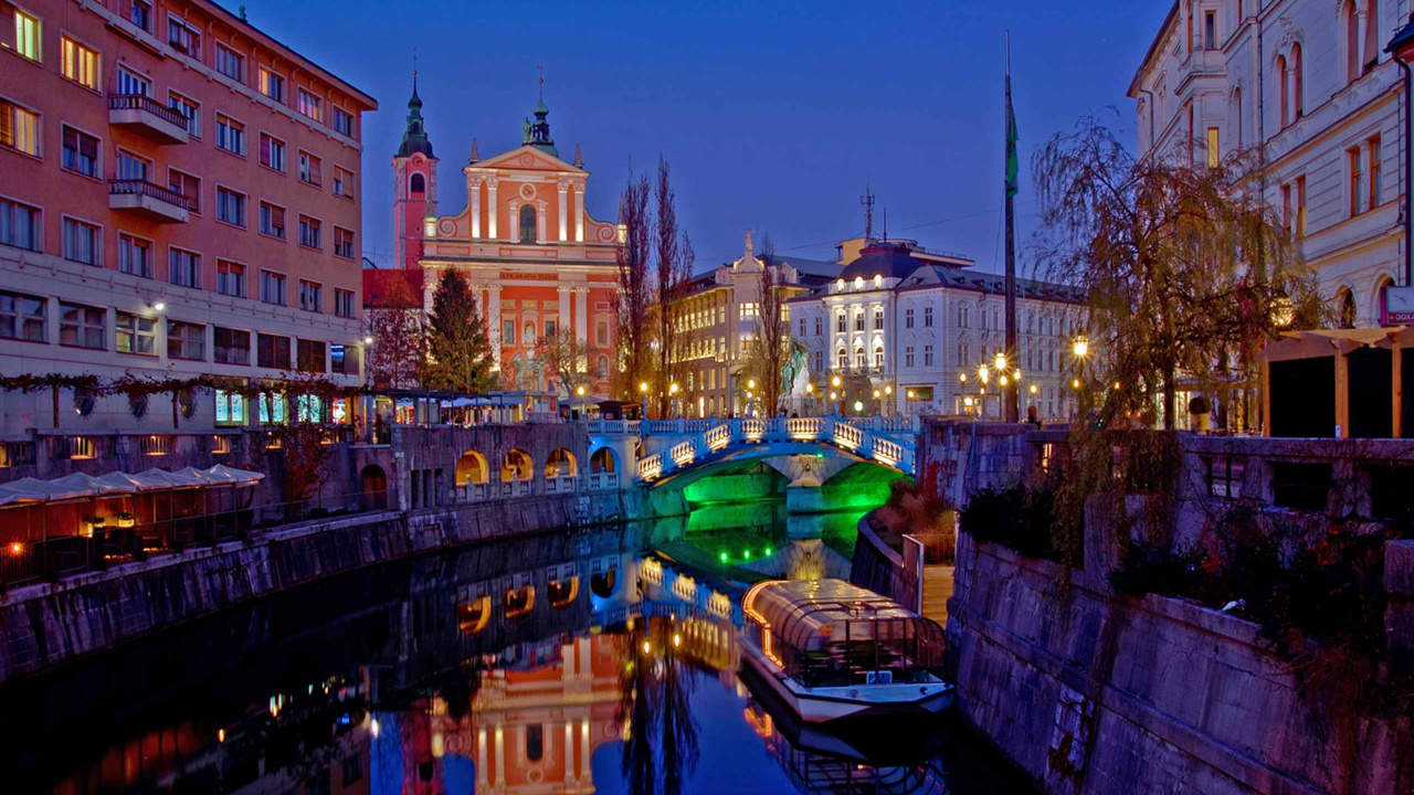 Bâtiment en Béton Brun Près D'un Plan D'eau Pendant la Nuit. Wallpaper in 1280x720 Resolution