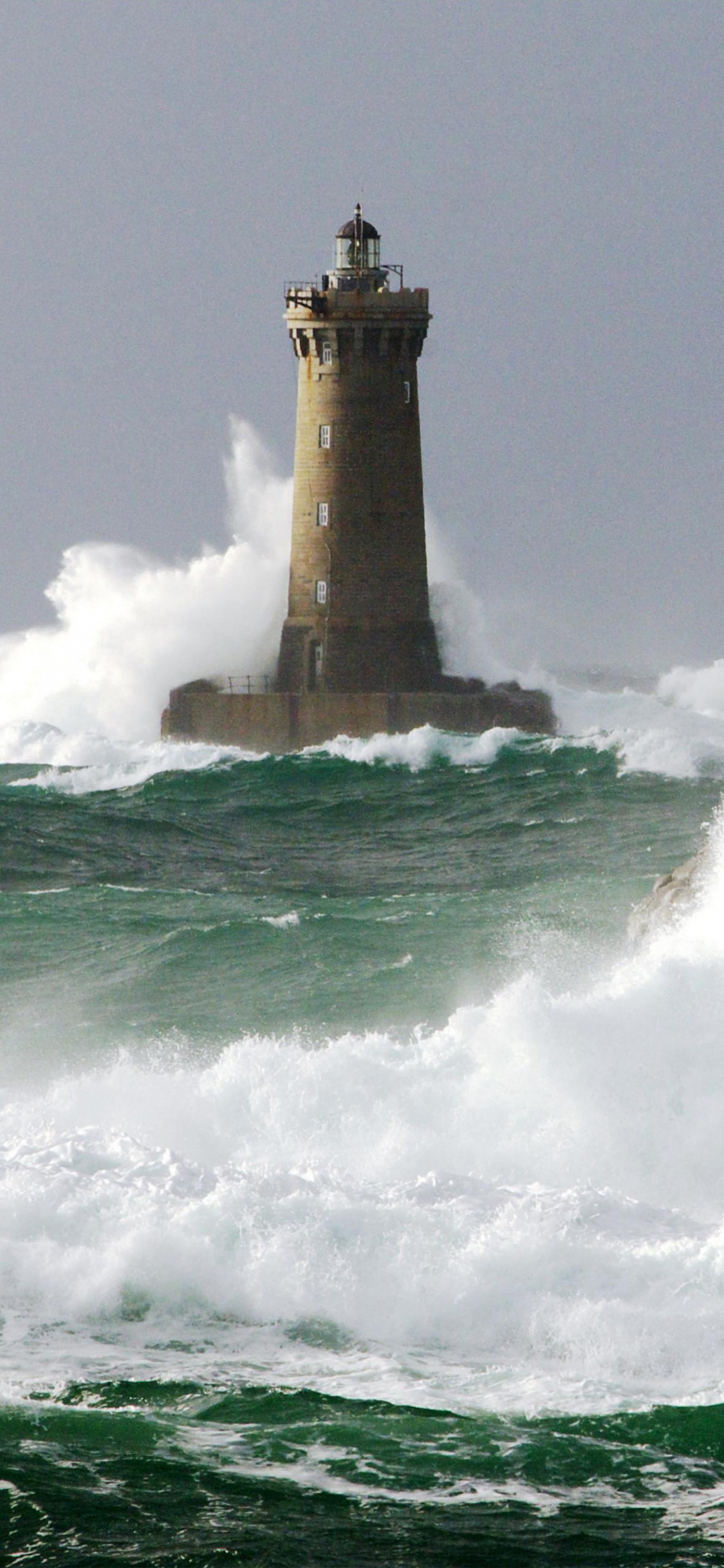 Phare Marron et Blanc au Sommet de la Colline. Wallpaper in 1125x2436 Resolution