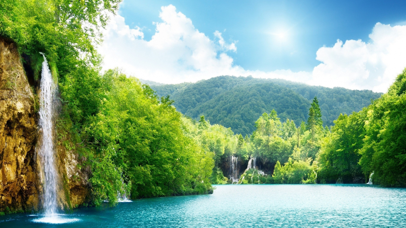 Grüne Bäume Neben Dem Fluss Unter Blauem Himmel Tagsüber. Wallpaper in 1366x768 Resolution