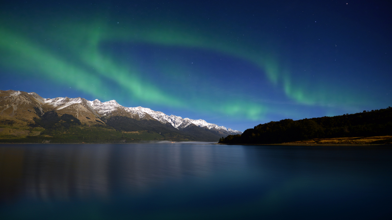 Snow Covered Mountain Beside Body of Water During Daytime. Wallpaper in 1280x720 Resolution