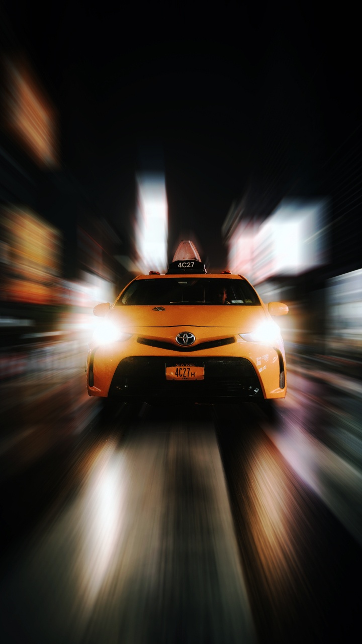 Gelbes Auto Auf Der Straße Während Der Nachtzeit. Wallpaper in 720x1280 Resolution