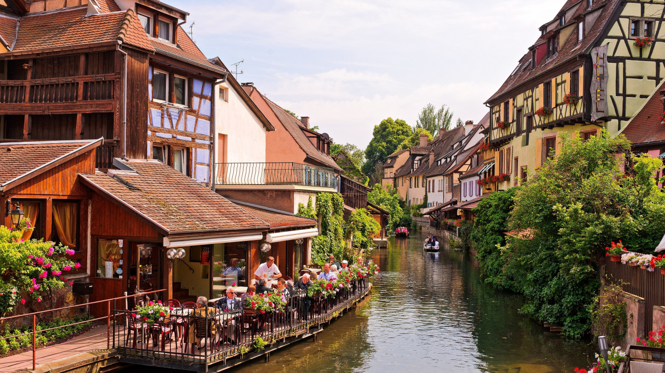 Leute, Die Tagsüber Auf Dem Bürgersteig Neben Dem Fluss Spazieren Gehen. Wallpaper in 1366x768 Resolution