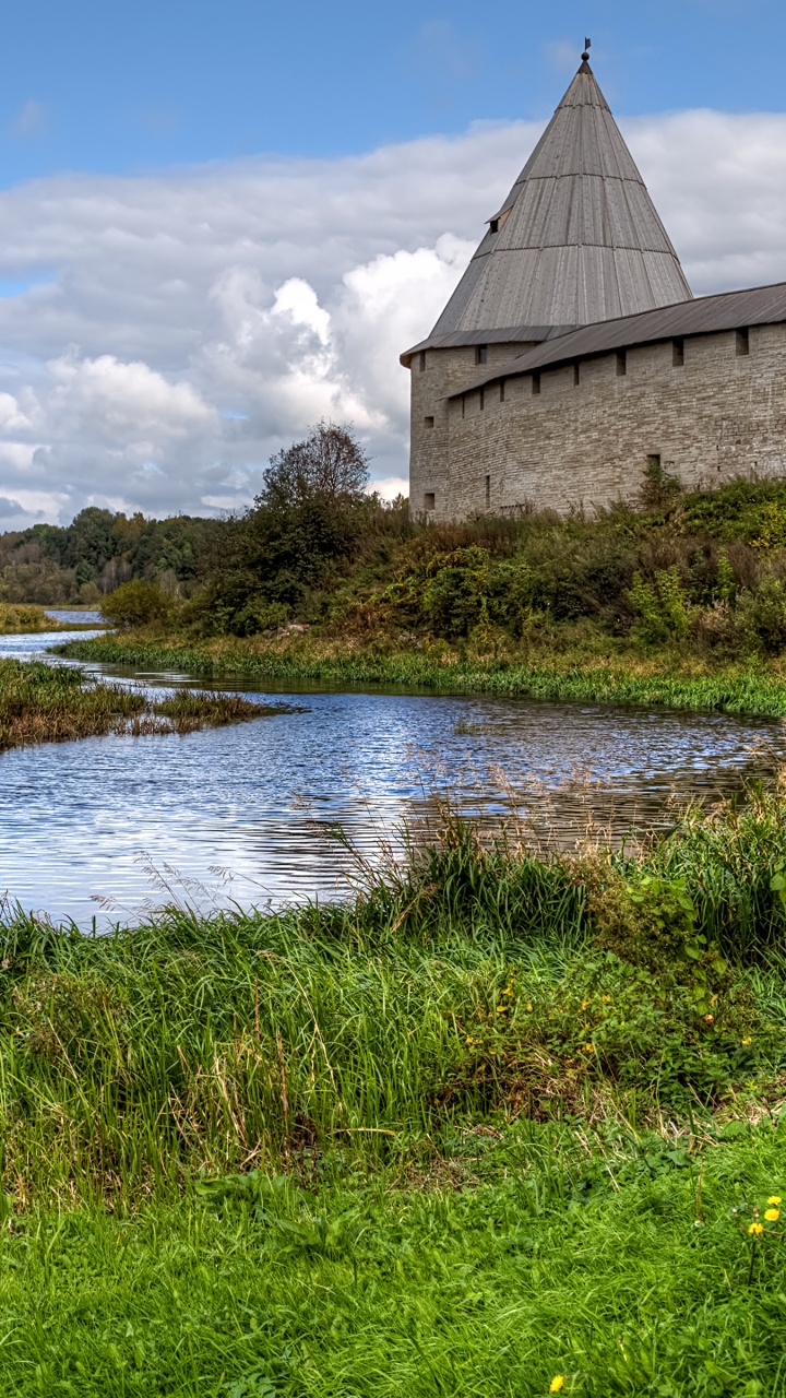 Brown Concrete Building Near River Under White Clouds and Blue Sky During Daytime. Wallpaper in 720x1280 Resolution