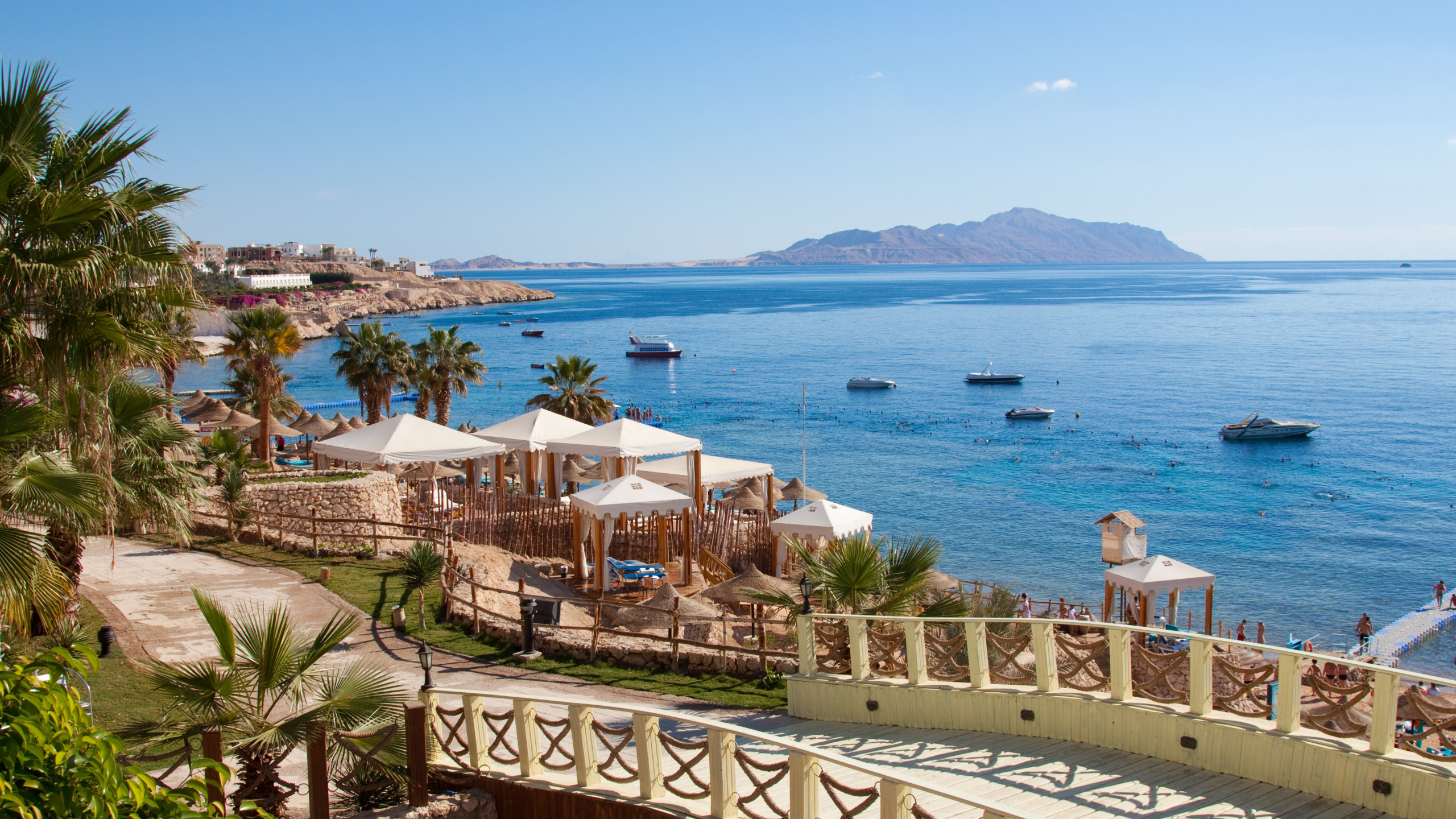 White and Brown Concrete Building Near Body of Water During Daytime. Wallpaper in 2560x1440 Resolution