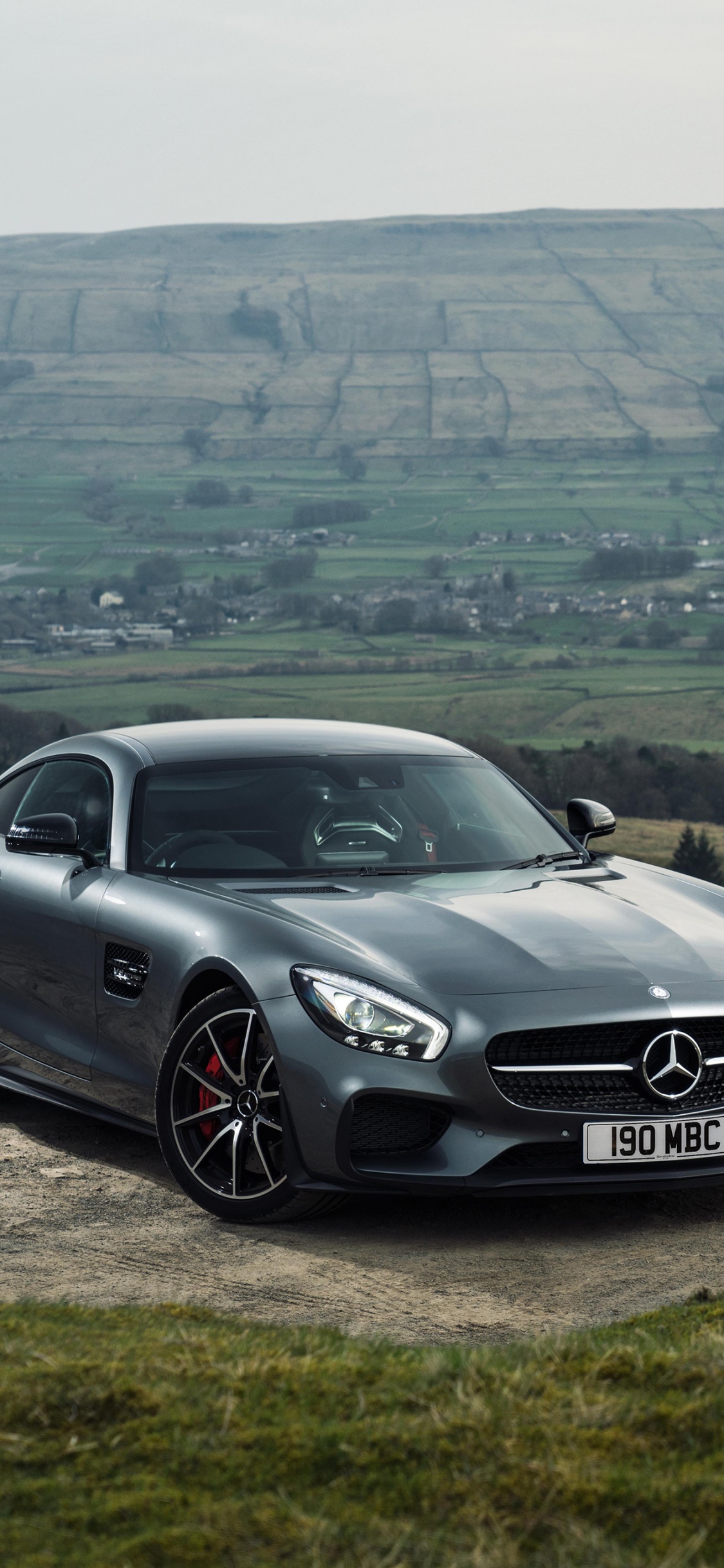 Mercedes Benz Coupé Noir Sur Terrain D'herbe Verte Pendant la Journée. Wallpaper in 1125x2436 Resolution