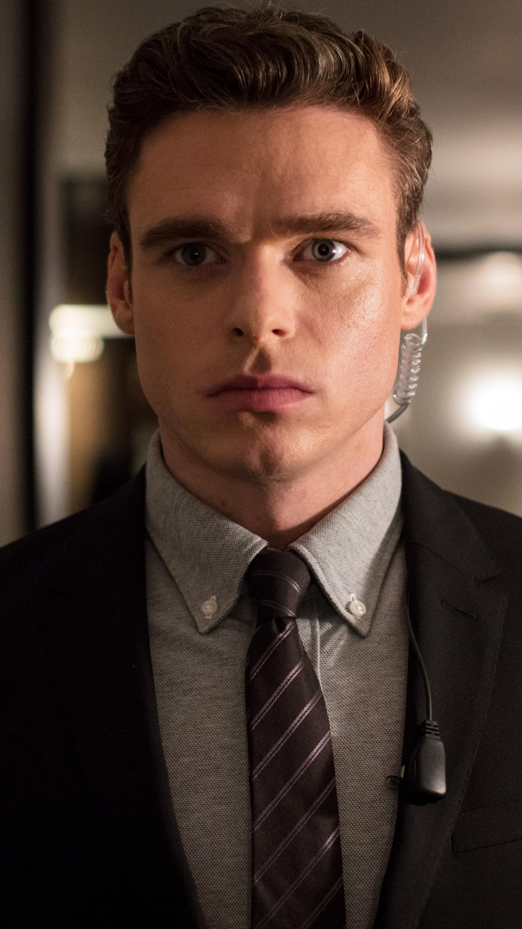 Hombre Con Chaqueta de Traje Negro de Pie Junto a Una Mujer Con Chaqueta Negra. Wallpaper in 750x1334 Resolution