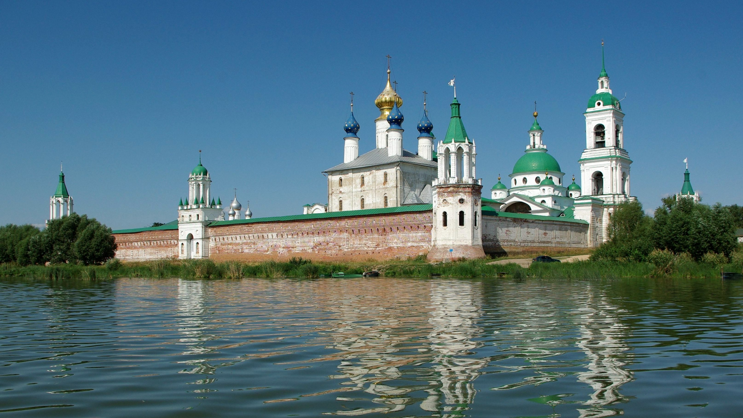 Weißes Und Braunes Betongebäude Neben Dem Gewässer Tagsüber. Wallpaper in 2560x1440 Resolution