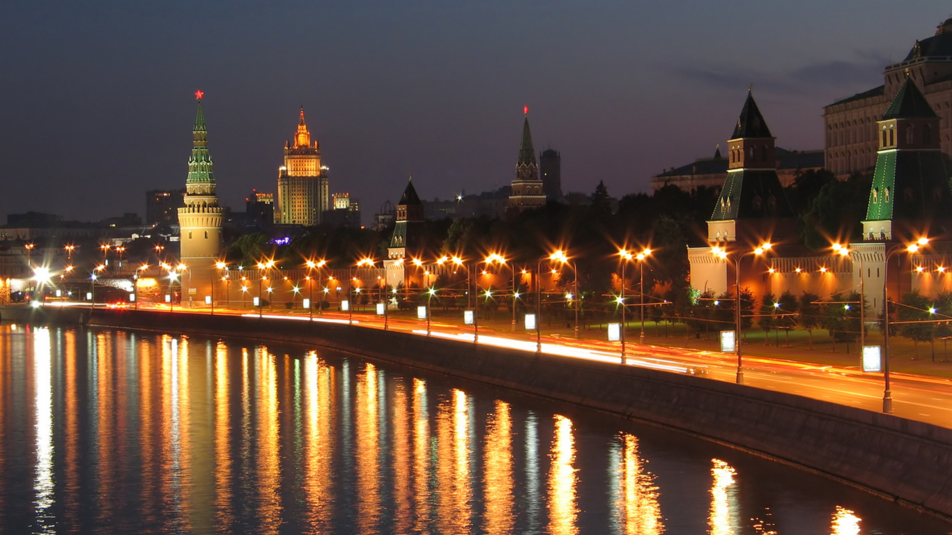 Lighted City Buildings Near Body of Water During Night Time. Wallpaper in 1366x768 Resolution