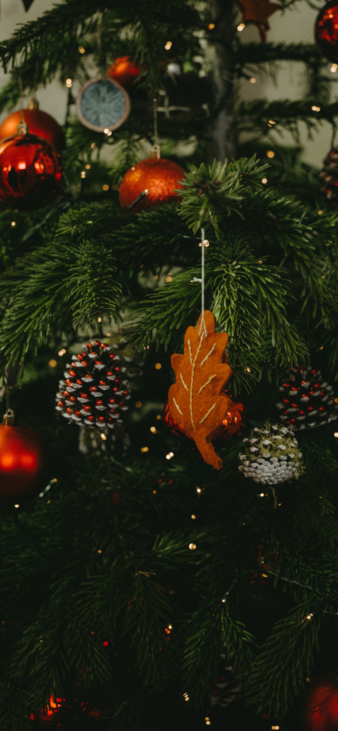 Grüner Weihnachtsbaum Mit Roten Kugeln. Wallpaper in 1125x2436 Resolution