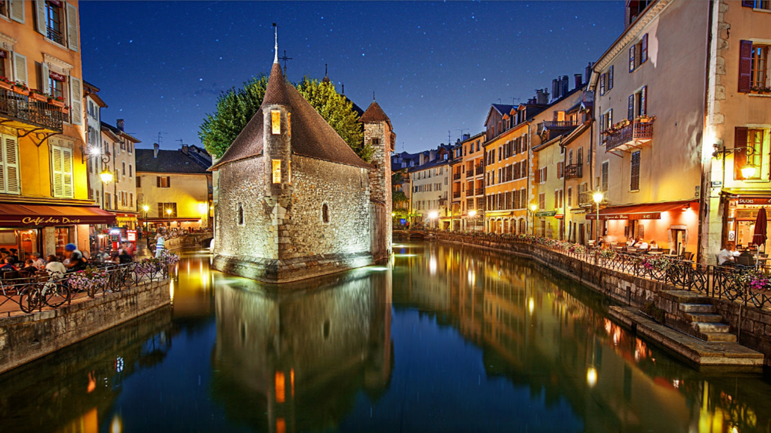 Braunes Betongebäude in Der Nähe Von Gewässern Während Der Nacht. Wallpaper in 2560x1440 Resolution