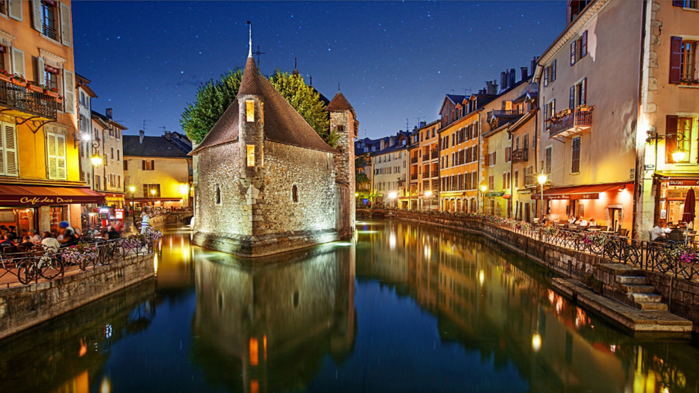 Edificio de Hormigón Marrón Cerca Del Cuerpo de Agua Durante la Noche. Wallpaper in 1366x768 Resolution