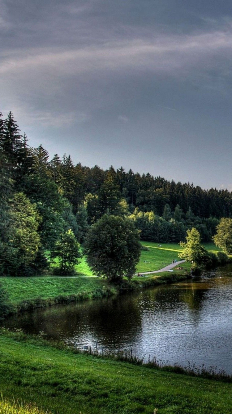 Grüne Bäume Neben Dem Fluss Unter Bewölktem Himmel Tagsüber. Wallpaper in 750x1334 Resolution