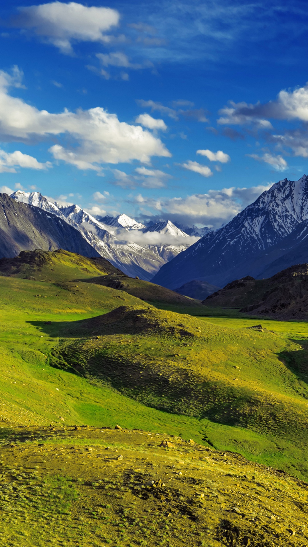 Green Grass Field Near Mountains Under Blue Sky During Daytime. Wallpaper in 1080x1920 Resolution